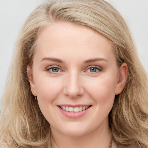 Joyful white young-adult female with long  brown hair and blue eyes