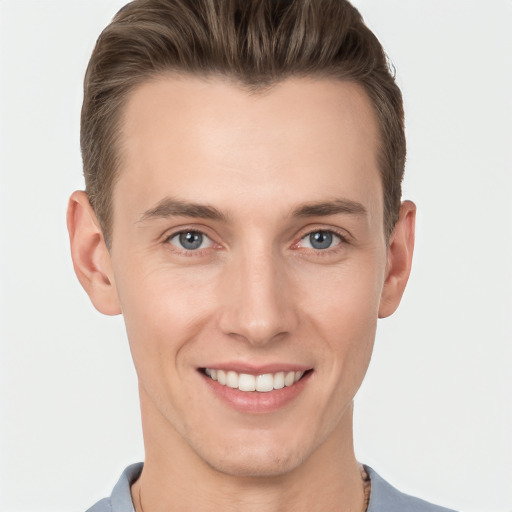 Joyful white young-adult male with short  brown hair and grey eyes