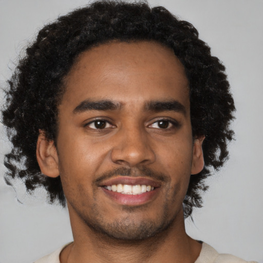 Joyful black young-adult male with short  brown hair and brown eyes
