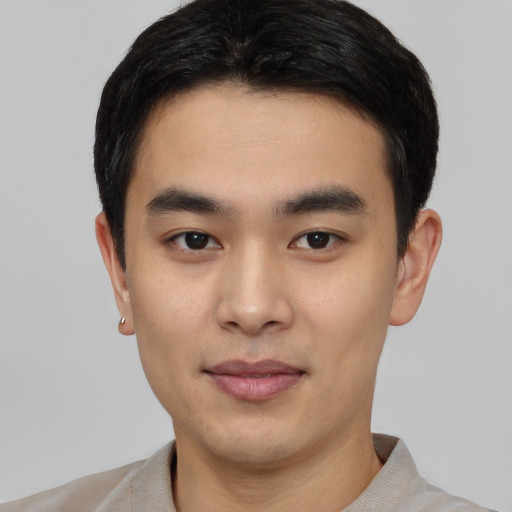 Joyful asian young-adult male with short  black hair and brown eyes