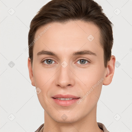 Joyful white young-adult male with short  brown hair and grey eyes