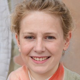 Joyful white adult female with medium  brown hair and blue eyes