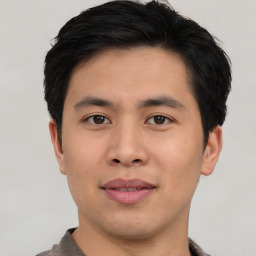 Joyful asian young-adult male with short  black hair and brown eyes