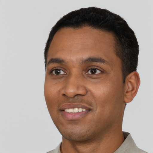 Joyful black young-adult male with short  black hair and brown eyes