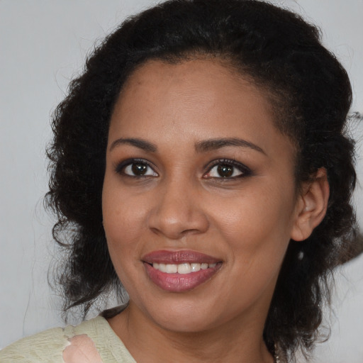 Joyful black young-adult female with medium  brown hair and brown eyes