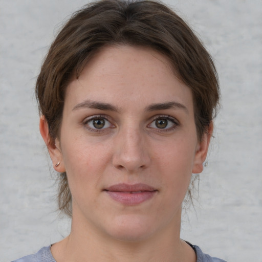 Joyful white young-adult female with short  brown hair and grey eyes