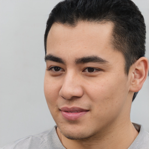 Joyful latino young-adult male with short  brown hair and brown eyes