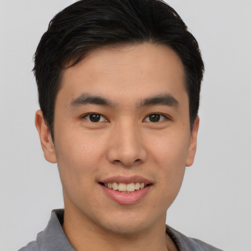 Joyful asian young-adult male with short  brown hair and brown eyes