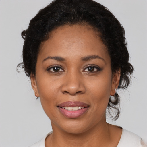 Joyful black young-adult female with medium  black hair and brown eyes