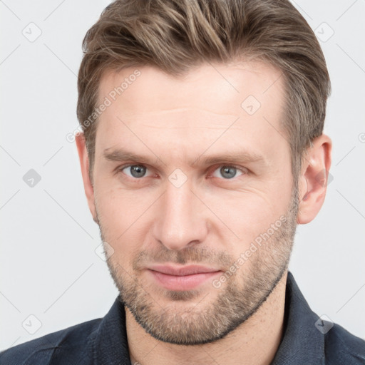 Joyful white young-adult male with short  brown hair and grey eyes