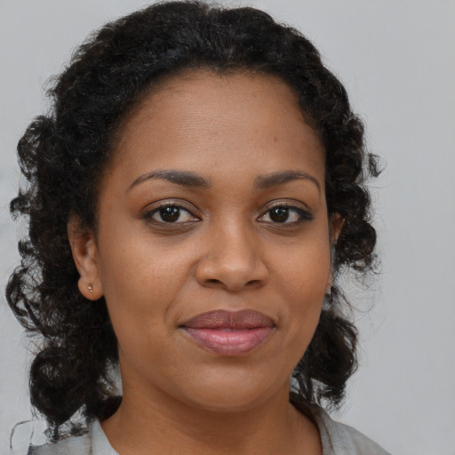 Joyful black adult female with medium  brown hair and brown eyes