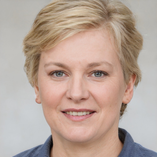 Joyful white adult female with medium  brown hair and blue eyes