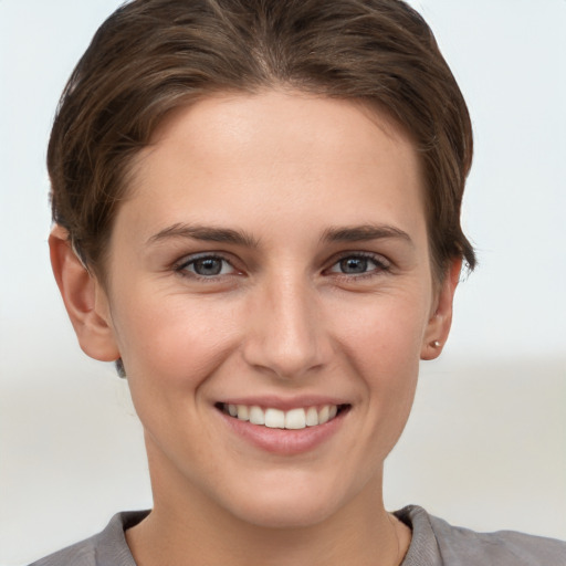 Joyful white young-adult female with short  brown hair and grey eyes