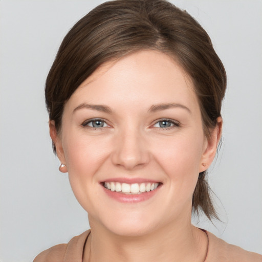 Joyful white young-adult female with medium  brown hair and grey eyes