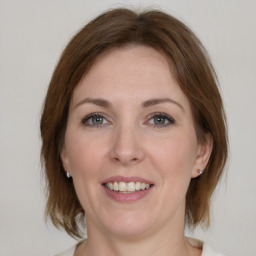 Joyful white young-adult female with medium  brown hair and green eyes