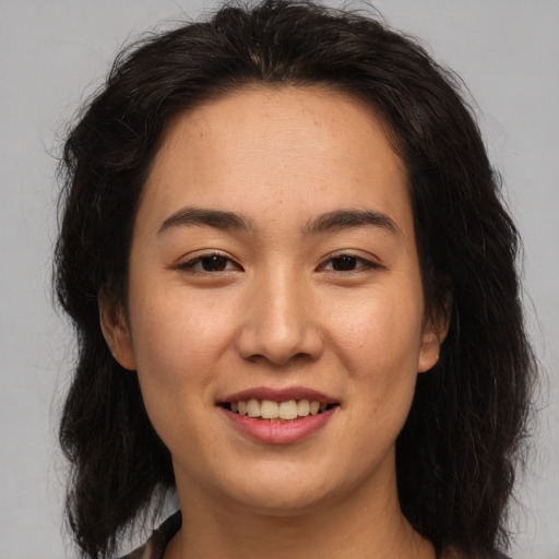 Joyful asian young-adult female with long  brown hair and brown eyes