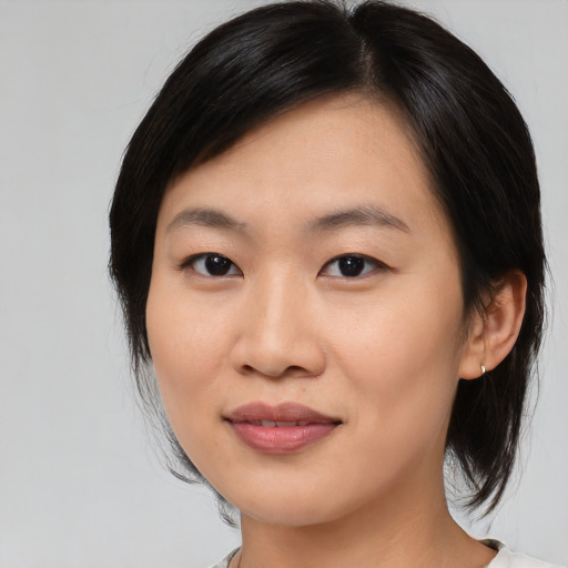 Joyful asian young-adult female with medium  black hair and brown eyes