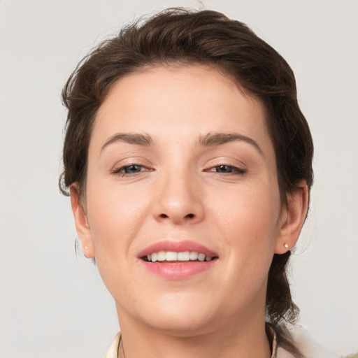 Joyful white young-adult female with medium  brown hair and grey eyes