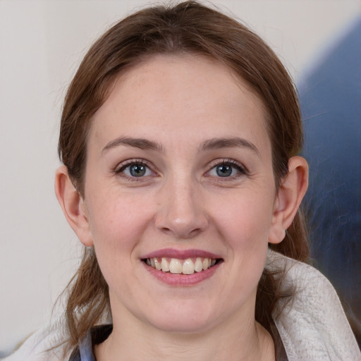 Joyful white young-adult female with medium  brown hair and blue eyes