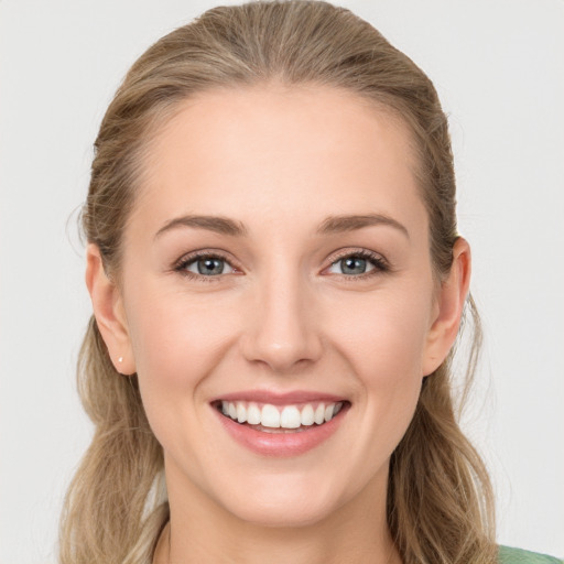 Joyful white young-adult female with long  brown hair and green eyes