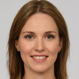 Joyful white young-adult female with long  brown hair and green eyes