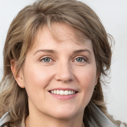 Joyful white young-adult female with medium  brown hair and blue eyes