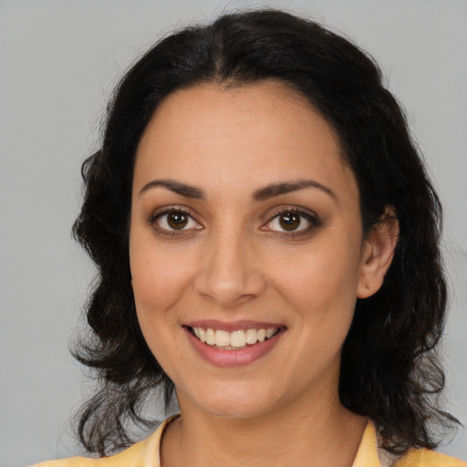 Joyful latino young-adult female with medium  brown hair and brown eyes
