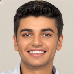 Joyful white young-adult male with short  black hair and brown eyes