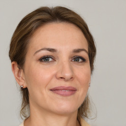 Joyful white adult female with medium  brown hair and grey eyes