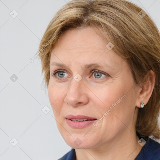 Joyful white adult female with medium  brown hair and blue eyes