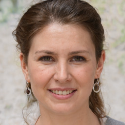 Joyful white adult female with medium  brown hair and grey eyes