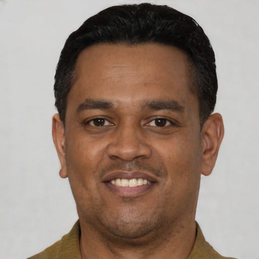 Joyful latino young-adult male with short  black hair and brown eyes
