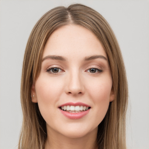 Joyful white young-adult female with long  brown hair and green eyes