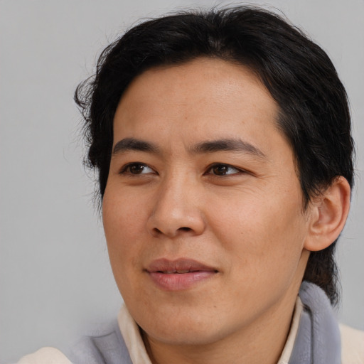 Joyful asian young-adult male with medium  brown hair and brown eyes