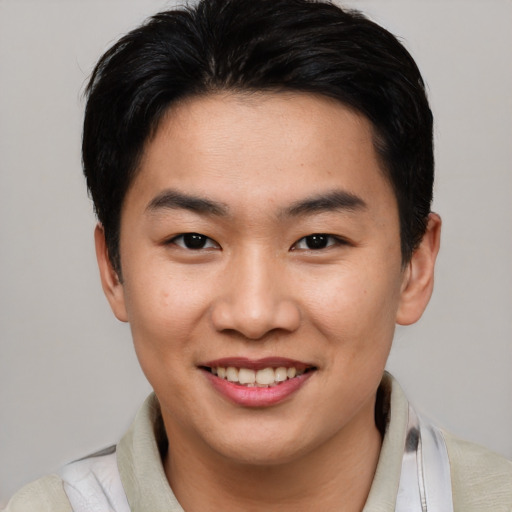 Joyful asian young-adult male with short  brown hair and brown eyes