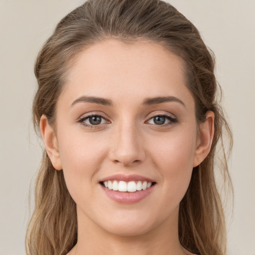 Joyful white young-adult female with long  brown hair and grey eyes