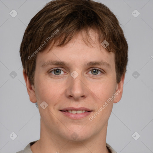 Joyful white young-adult male with short  brown hair and grey eyes