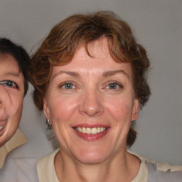 Joyful white adult female with medium  brown hair and blue eyes