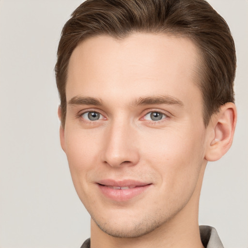 Joyful white young-adult male with short  brown hair and grey eyes