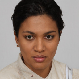 Joyful latino young-adult female with short  brown hair and brown eyes
