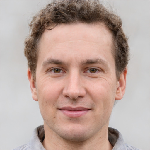 Joyful white adult male with short  brown hair and grey eyes