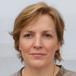 Joyful white adult female with medium  brown hair and grey eyes