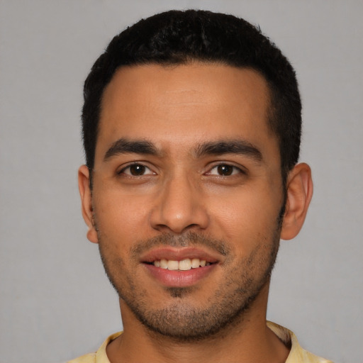 Joyful latino young-adult male with short  black hair and brown eyes