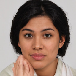 Joyful latino young-adult female with medium  brown hair and brown eyes