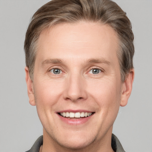 Joyful white adult male with short  brown hair and grey eyes