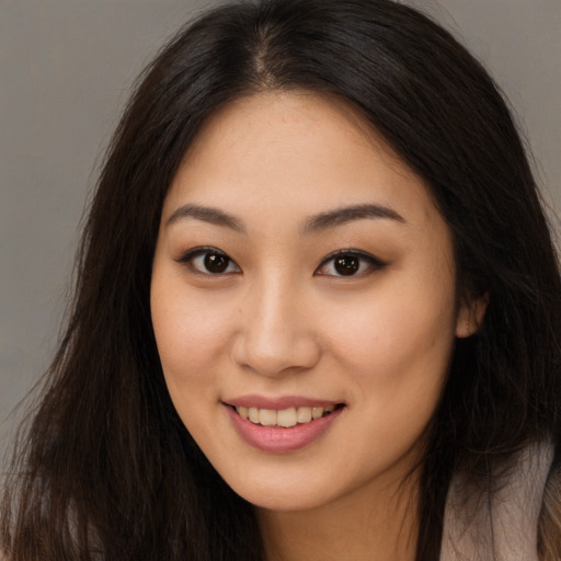 Joyful asian young-adult female with long  brown hair and brown eyes