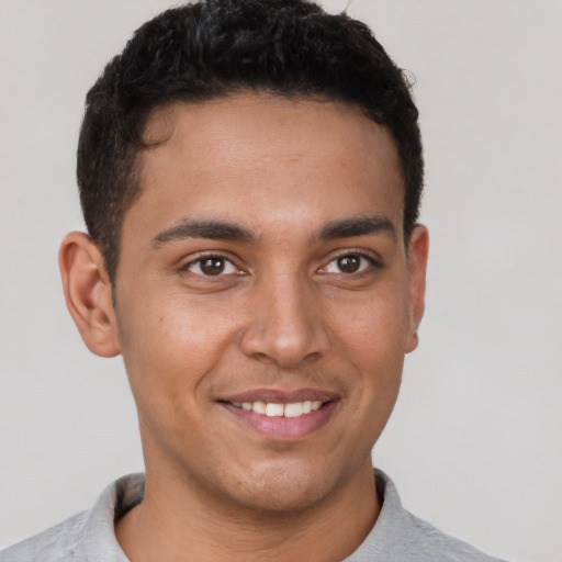 Joyful latino young-adult male with short  brown hair and brown eyes