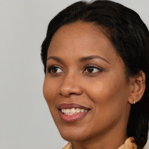 Joyful black young-adult female with medium  black hair and brown eyes
