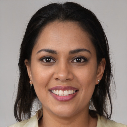 Joyful latino young-adult female with medium  brown hair and brown eyes