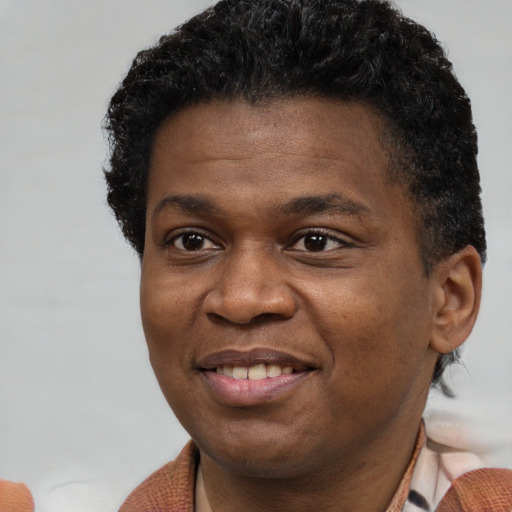 Joyful black adult male with short  brown hair and brown eyes